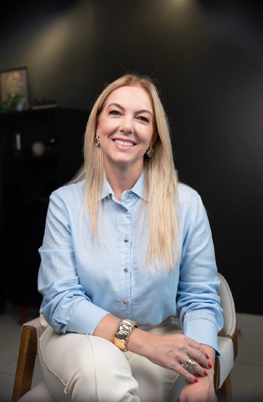 Psicóloga Geórgia Mauad sorrindo em seu consultório